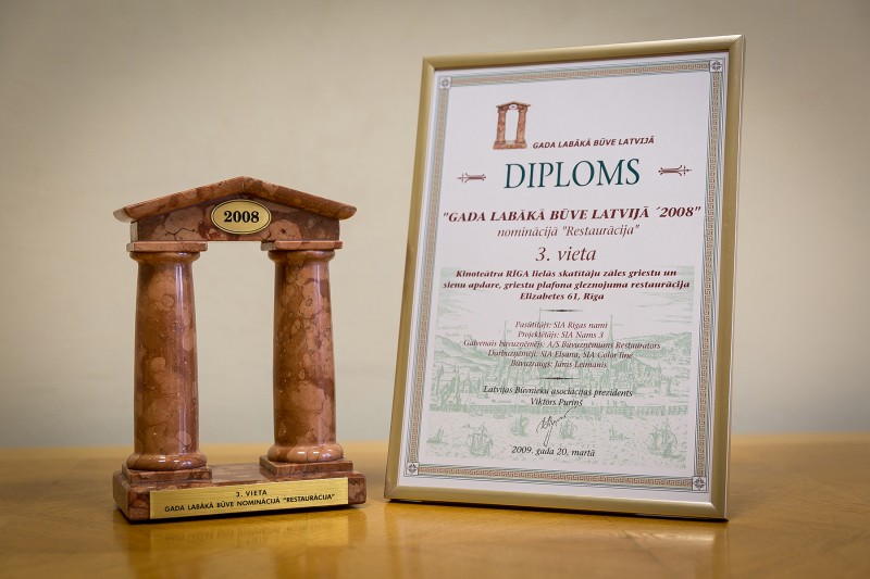 AS “Būvuzņēmums Restaurators” received recognition in the competition “Best Building in Latvia 2008” in the category “Restoration” (3rd place) on 20 March 2009. This award was granted for restoration of ceiling and wall finishing and ceiling painting of the Great Hall of cinema “Riga” (historical cinema “Splendid Palace”). The works were carried out in 2008.